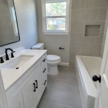 Bathroom remodel with white vanity and gray tile