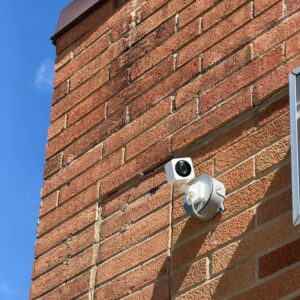 Outdoor security camera mounted on a weatherproof junction box on a brick wall